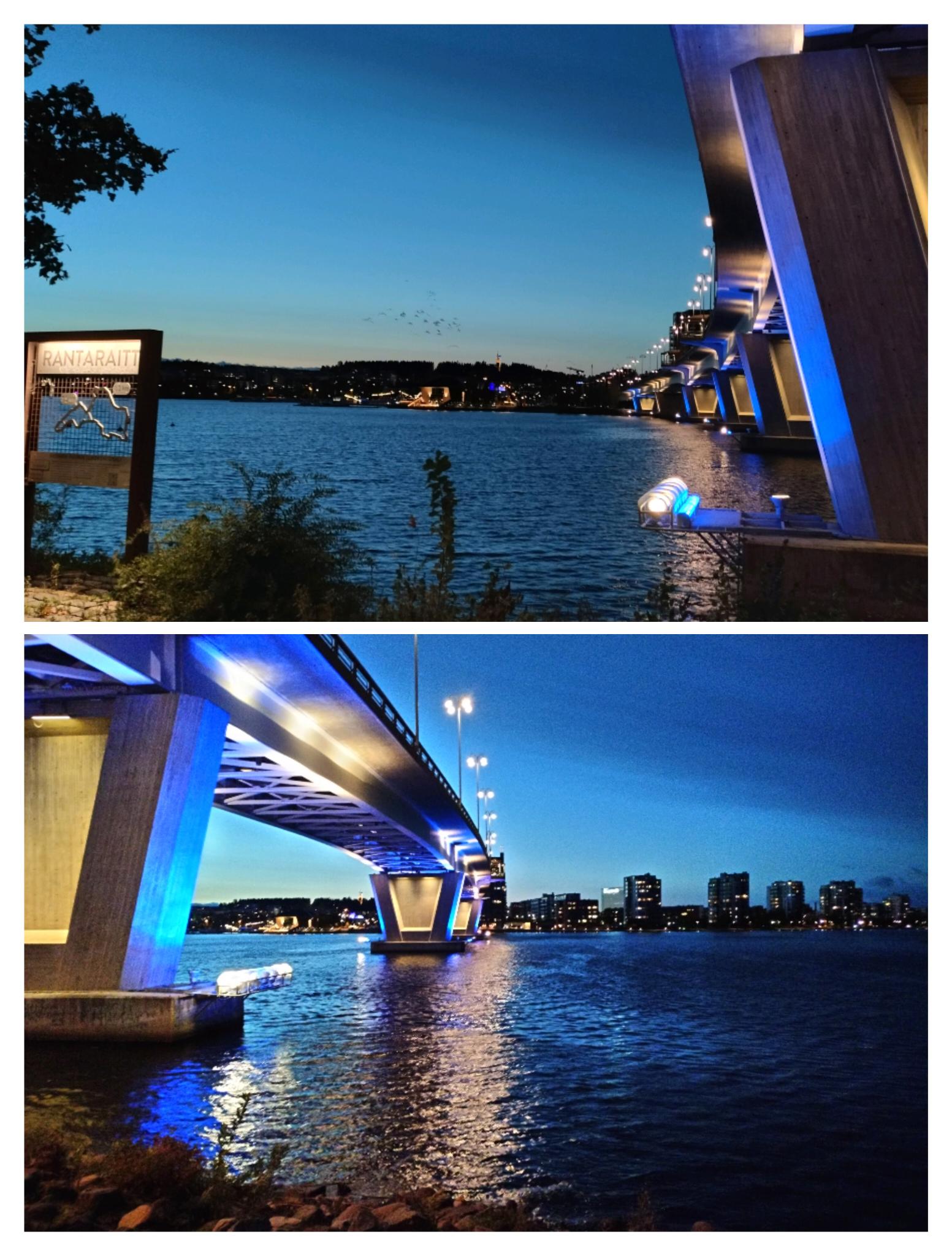 Eine beleuchtete Brücke über See in der Nacht.