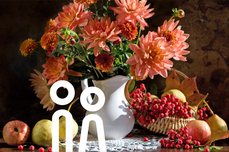 Herbstliches Stillleben mit orangefarbenen Blumen, Äpfeln, Birnen und roten Beeren auf einem gedeckten Tisch.