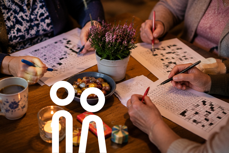 Menschen lösen gemeinsam Rätsel an einem Tisch mit Kerzenlicht, Kaffee und kleinen Gewinnen.