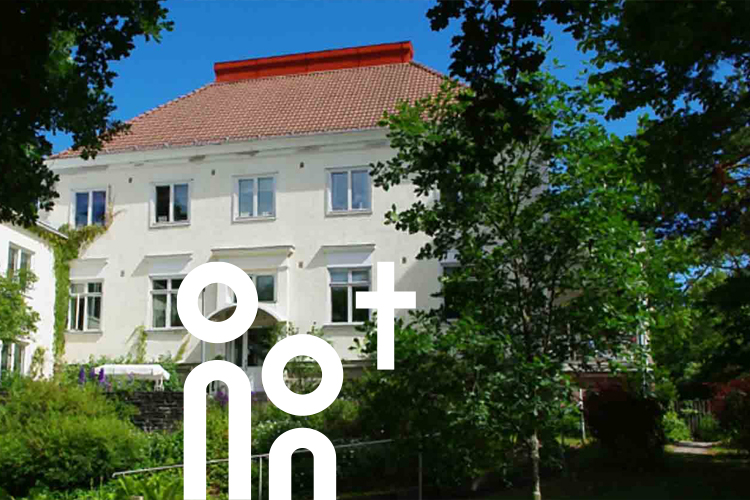 Blick aus dem Garten im Sommer hoch zum Seniorenwohnheim vom Meer aus gesehen.