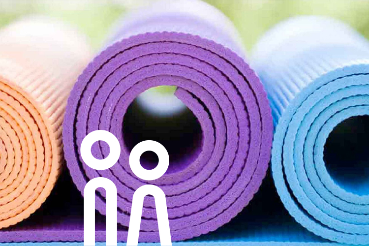 Aufgerollte Yoga–Matten in verschiedenen Farben.